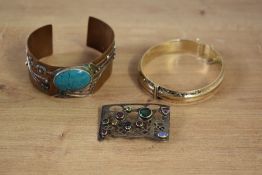 A Paula Bolton copper and turquoise cuff bangle, having blossom decoration with bezel set turquoise,