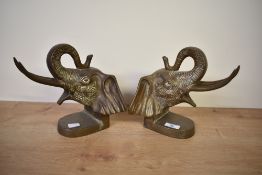 A pair of cast brass elephant head bookends each having trunk up forming a loop, h21cm