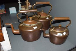 A set of 3 19th century copper kettles having shaped handle and spout, largest h28cm