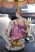 A 19th century style figural table lamp formed as a seated young woman, in period costume with guilt