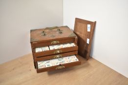 A Chinese Mahjong box set having brass corners and carry handles, fitted with 5 drawers complete