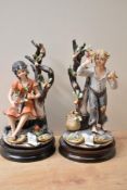 Two large vintage Capodimonte style figures depicting a male and female child amongst fruit trees,
