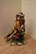 A Capodimonte porcelain figure group depicting a huntsman and a heir, measuring 27cm tall.