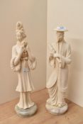 Two oriental cast composition figures depicting a male holding a scroll and a female holding a