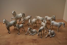 Twelve Royal Doulton bone china and Beswick Pottery horses and foals, all in dapple grey gloss