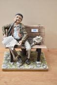 A large Capodimonte figure depicting a man on a bench smoking a pipe and reading the paper,