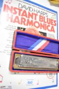 A vintage Hohner Chromatic Harmonica and a Dave Harp instruction book