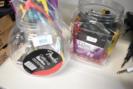 A selection of Fender and Kinsman patch cables and a tub of string winders