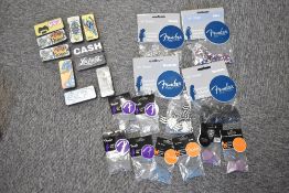A large selection of guitar picks including Fender and Dunlop illustrated pick tins