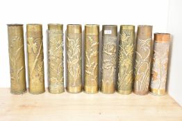 A group of nine French brass 75DEC Trench Art shell cases, each embossed in relief with foliate