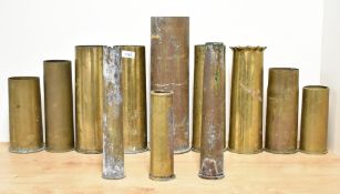 A group of eleven World War I brass shell cases, various calibers, undecorated apart from two with