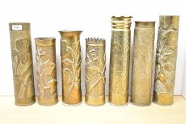 A group of seven French World War I brass Trench Art shell cases, each with embossed and hand-worked