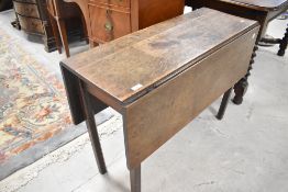 An early 19th Century dining table having narrow top and square gate legs, width approx. 97cm , open