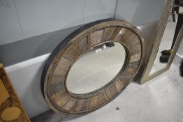 A rustic oak wall mirror of oval form, approx. 82 x 70cm