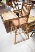 A vintage childs high/low chair, with wooden wheel attachment