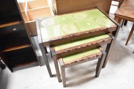 A vintage nest of three tile top tables, overall width 67cm
