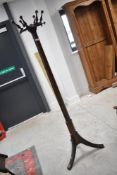 A late Victorian/Edwardian mahogany hat stand having revolving top and triple splay legs, height