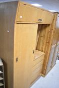 A mid Century golden oak bedroom unit in the Gomme G Plan style having sliding door wardrobe with