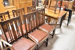 A set of six early to mid 20th century oak rail back dining chairs, a similar carver chair and a