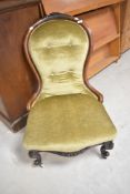 A Victorian mahogany framed nursing chair having green dralon upholstery with button back