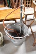 A vintage galvanised bucket having integral pump
