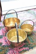 Three traditional brass jam pans, graduated sizes
