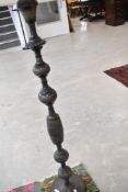 An Indian etched brass standard lamp, with modern cream shade