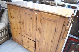 A modern pine childs double wardrobe having central cupboard and drawer section, width approx.