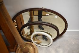 Three assorted oval wall mirrors