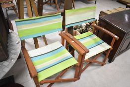 A pair of teak framed folding garden chairs in the directors style
