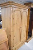 A natural pine wardrobe having drawer base, approx dimensions H200 W110 D56cm