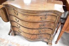 An early to mid 20th Century mahogany chest of serpentine form having brushing slide and four long