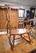 A traditional stained frame spindle back rocking chair
