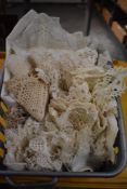 A small basket of assorted vintage linen and handmade lace items including table square, tray mat