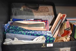 A vintage faux leather suitcase containing various fabric, mainly off cuts, to include cotton,