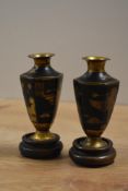 A pair of miniature Egyptian curio urn vases, decorated having gold coloured pharaohs on a black