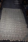 A vintage intricately crocheted tablecloth in cream 200cm x 145cm having two small age related marks