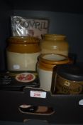 Three salt glazed jars, three vintage Twinings Tea tins and a reproduction Bovril advertising sign.