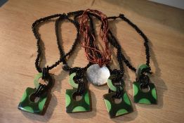 A collection of four matching coconut and beaded necklaces, the twisted black beaded necklaces