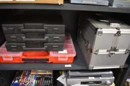 Five assorted storage cases including a metal bodied case.