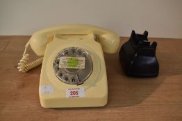 A retro beige plug in telephone having a rotary dial and coiled cable, w19cm.