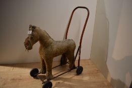 A vintage Tri-ang push along horse in need of restoration