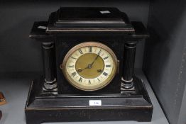 A 19th century black 8 day mantel clock having black Roman numerals on a cream chapter ring with a