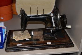 A late 19th / early 20th century Singer style sewing machine, supported on an ebonised wooden