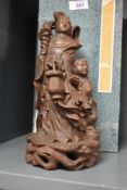 An early 20th century Chinese wooden sculpture having carved female figure with a boy by her side,