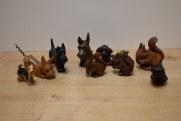 A group of carved dog and squirrel figures, one with corkscrew tail, sold together with a pottery
