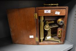 A 19th century brass monocular microscope in fitted oak carry case with glass slides, h25cm