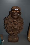 A tribal Nkisi/Nkondi fetish figure having painted eyes with nail and rope fragments around the