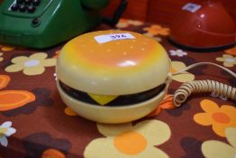A retro novelty hamburger telephone having flip top with large button dials, L10cm