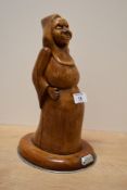 A carved wooden Monk figure having aluminium base and plaque reading 'Amen', h27cm
